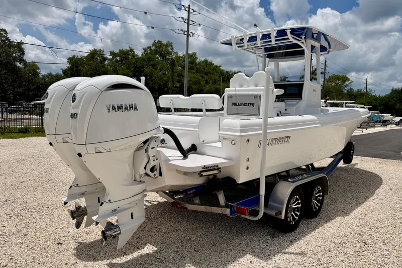 Slide: The Image of 2025 Bluewater 25t boat with dual Yamaha engines on a trailer, parked outdoors. - 4