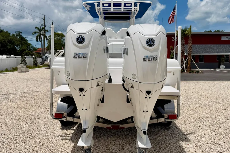 Slide: The Image of 2025 Bluewater 25t boat with dual Yamaha 200 outboard engines, parked on gravel. - 5