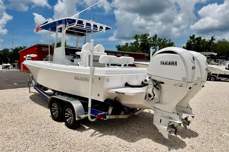 Slide: The Image of 2025 Bluewater 25t boat with Yamaha engines on a trailer, parked outdoors. - 6