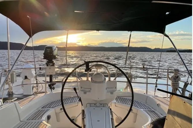 Slide: The Image of Cockpit view of 2003 Beneteau 423 sailboat at sunset on open water. - 10