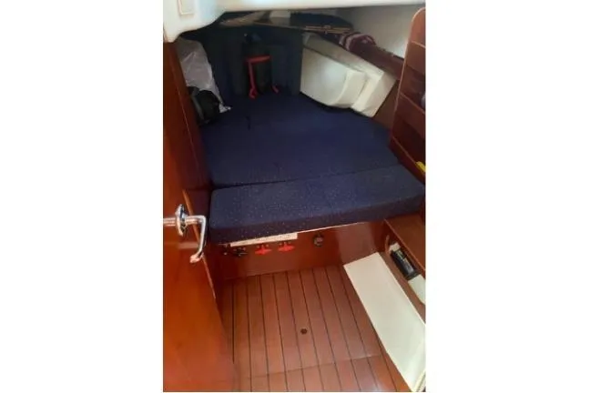 Slide: The Image of Interior cabin of 2003 Beneteau 423 sailboat with wooden flooring and blue cushions. - 17