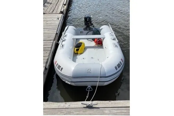 Slide: The Image of Inflatable dinghy docked beside a wooden pier, associated with a 2003 Beneteau 423. - 24