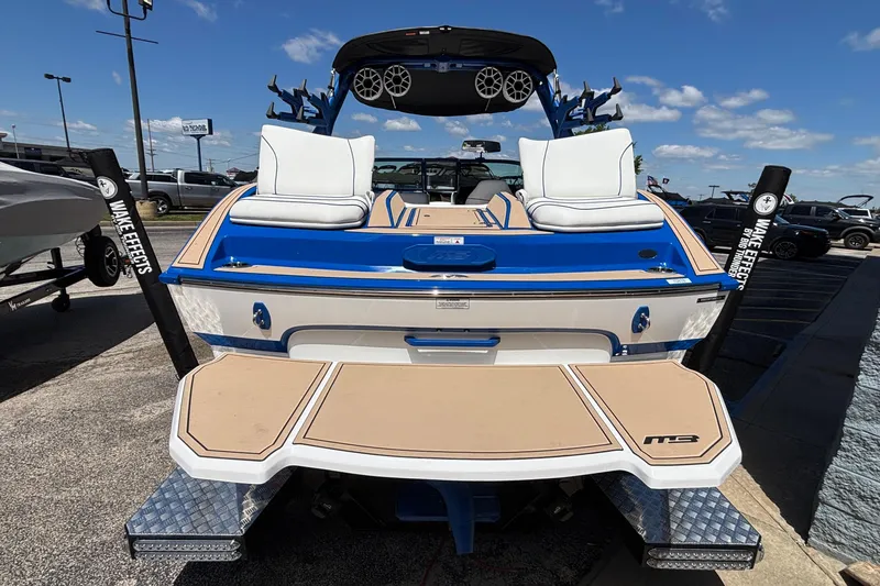 Slide: The Image of 2026 MB B52 23 Alpha boat with blue and white design, featuring wakeboard tower and speakers. - 12