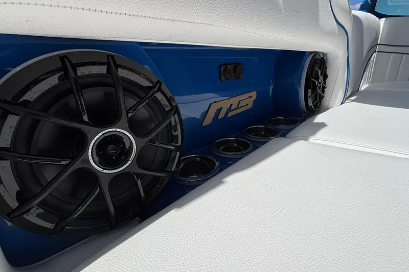 Slide: The Image of Interior of 2026 MB B52 23 Alpha boat with premium speakers and white seating. - 23