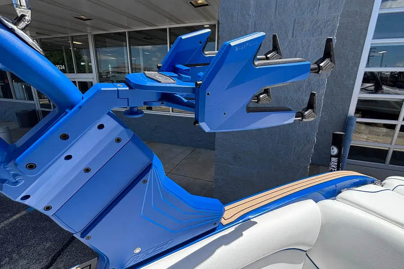 Slide: The Image of 2026 MB B52 23 Alpha boat with blue wakeboard rack, docked near a building. - 31