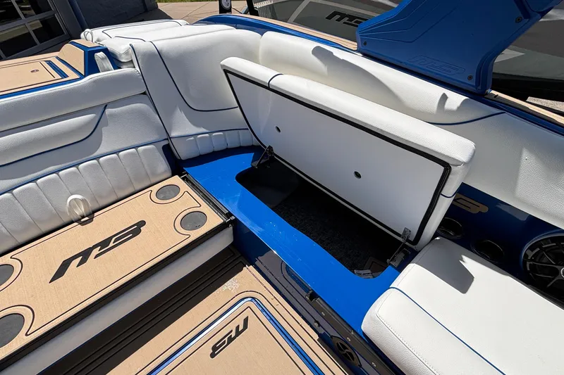 Slide: The Image of 2026 MB B52 23 Alpha boat interior with open storage compartment, white and blue seating. - 33