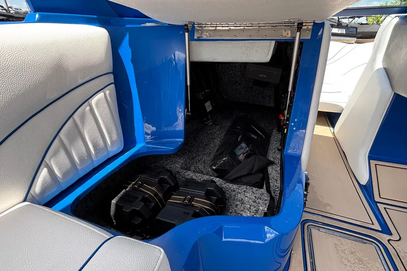 Slide: The Image of Interior view of 2026 MB B52 23 Alpha boat, featuring blue and white seating and storage area. - 36