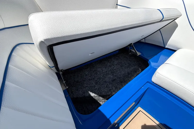 Slide: The Image of Open storage compartment in 2026 MB B52 23 Alpha boat with white seating and blue accents. - 54