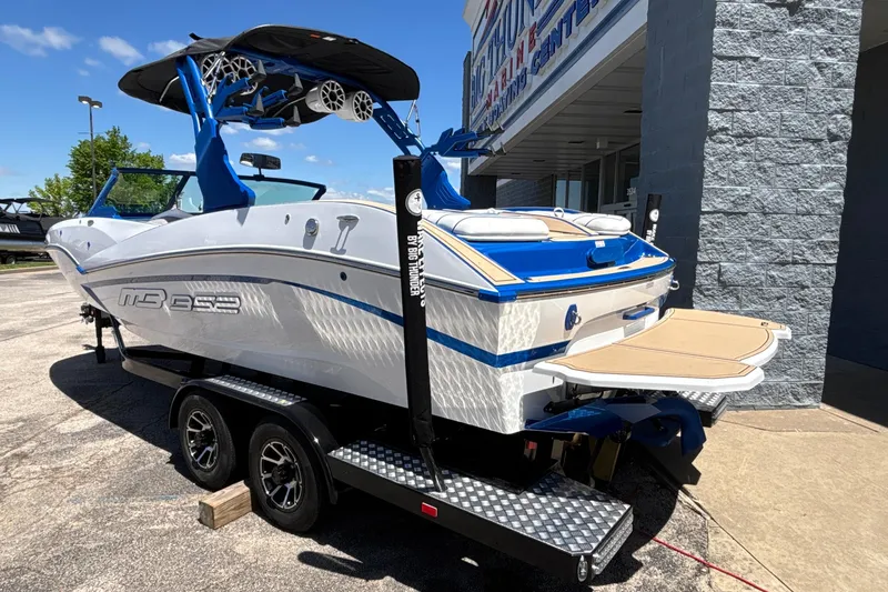 Slide: The Image of 2026 MB B52 23 Alpha boat on trailer, featuring sleek design and vibrant blue accents. - 7
