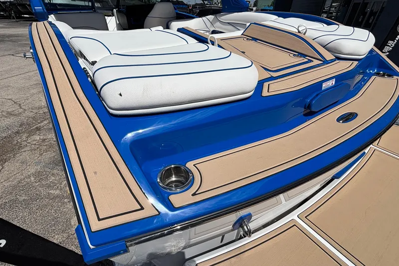 Slide: The Image of 2026 MB B52 23 Alpha boat with blue and tan deck, featuring white cushioned seating. - 8