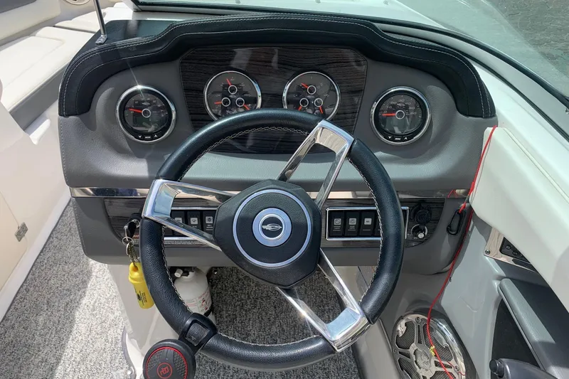 Slide: The Image of Steering wheel and dashboard of 2014 Chaparral 206 SSi boat, featuring gauges and controls. - 6