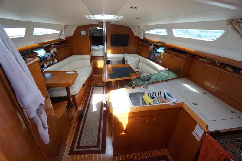 Slide: The Image of Teak deck of 2004 Jeanneau Sun Odyssey 37 sailboat, featuring blue tarp-covered equipment. - 5