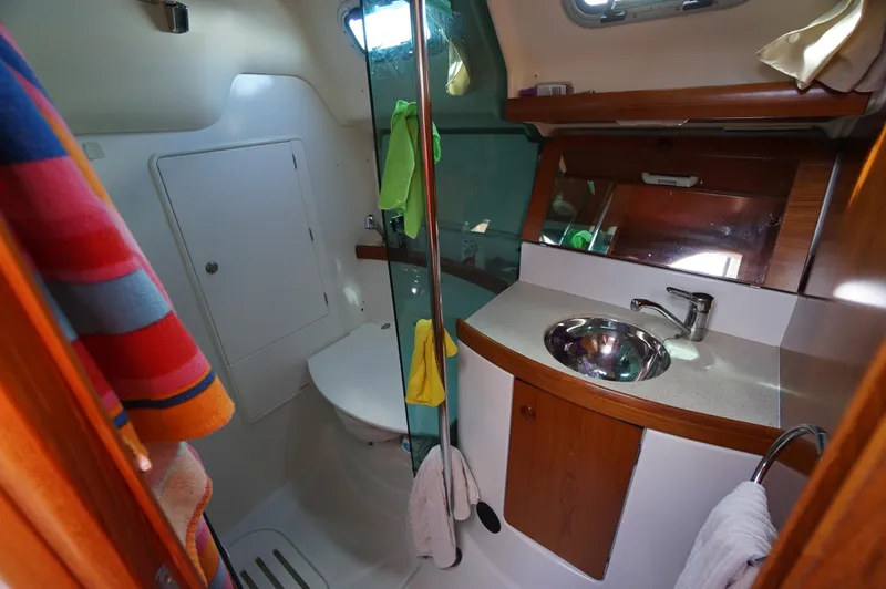 Slide: The Image of Teak deck of 2004 Jeanneau Sun Odyssey 37 sailboat, featuring blue tarp and rope. - 8