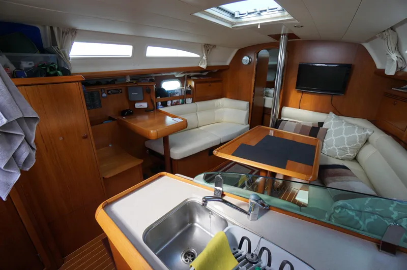 Slide: The Image of Teak deck of 2004 Jeanneau Sun Odyssey 37 sailboat, featuring clean lines and covered equipment. - 9