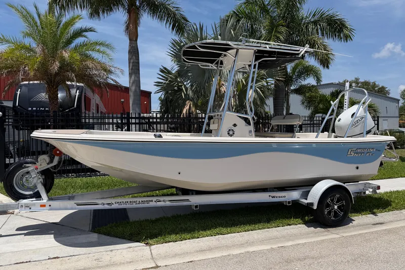 The Image of 2023 Carolina Skiff 21 LS boat on trailer, parked near palm trees. - 1