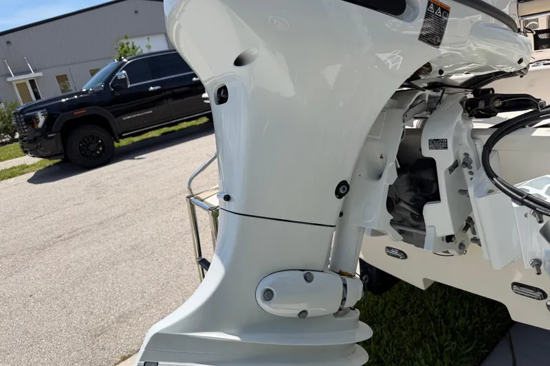 Slide: The Image of 2023 Carolina Skiff 21 LS boat motor detail with a black truck in the background. - 15
