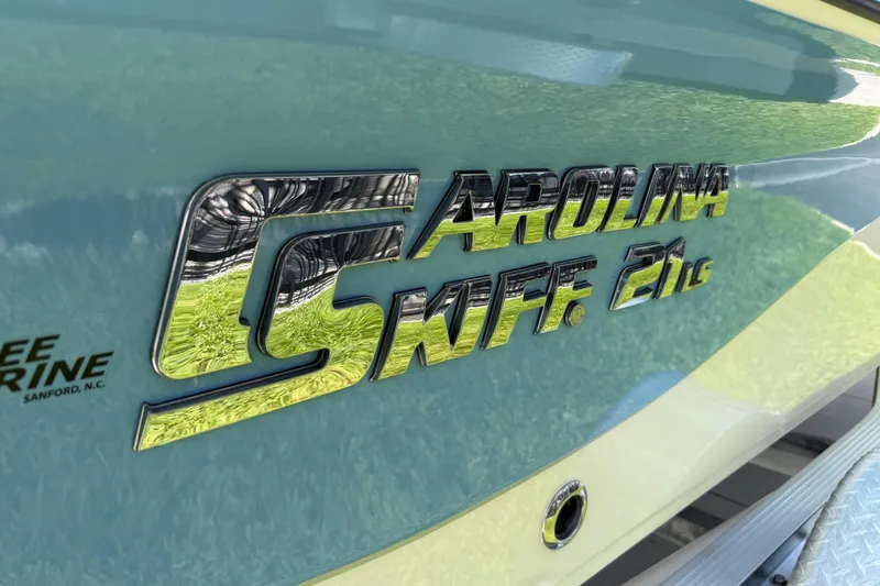 Slide: The Image of 2023 Carolina Skiff 21 LS boat logo on a sleek, blue hull. - 18