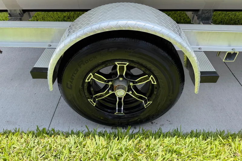 Slide: The Image of Trailer wheel of 2023 Carolina Skiff 21 LS with black alloy rim and tire. - 21
