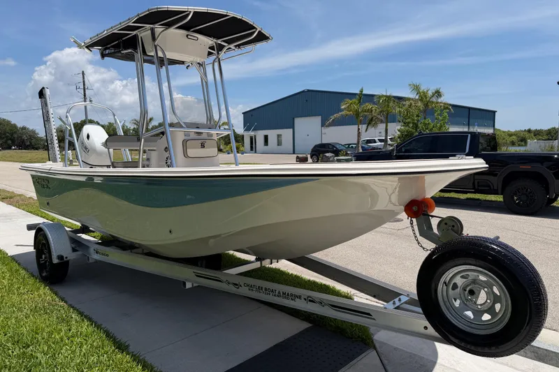 Slide: The Image of 2023 Carolina Skiff 21 LS boat on trailer, parked outdoors under clear sky. - 22