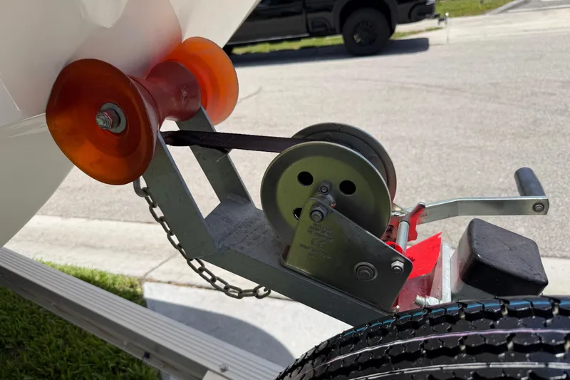 Slide: The Image of Trailer winch and roller for 2023 Carolina Skiff 21 LS boat, parked on a sunny street. - 24