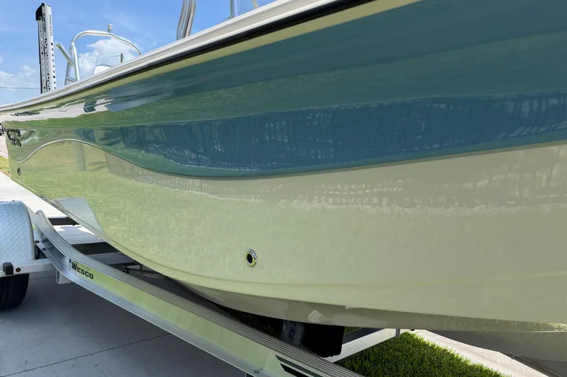 Slide: The Image of 2023 Carolina Skiff 21 LS boat on trailer, showcasing sleek blue and white hull design. - 25