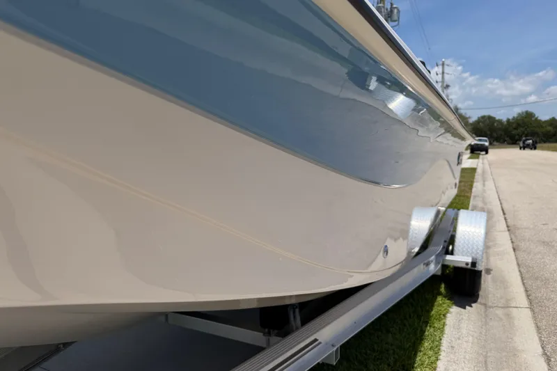 Slide: The Image of 2023 Carolina Skiff 21 LS boat on trailer, side view under sunny sky. - 27
