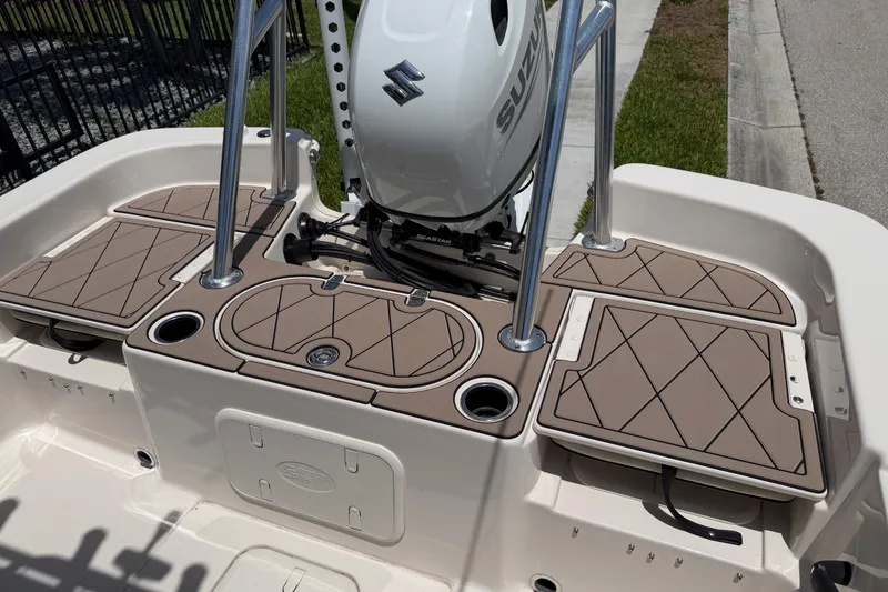 Slide: The Image of 2023 Carolina Skiff 21 LS boat deck with Suzuki motor and tan cushioned seating. - 38