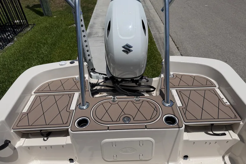 Slide: The Image of 2023 Carolina Skiff 21 LS boat deck with Suzuki outboard motor, featuring tan cushioned seating. - 39