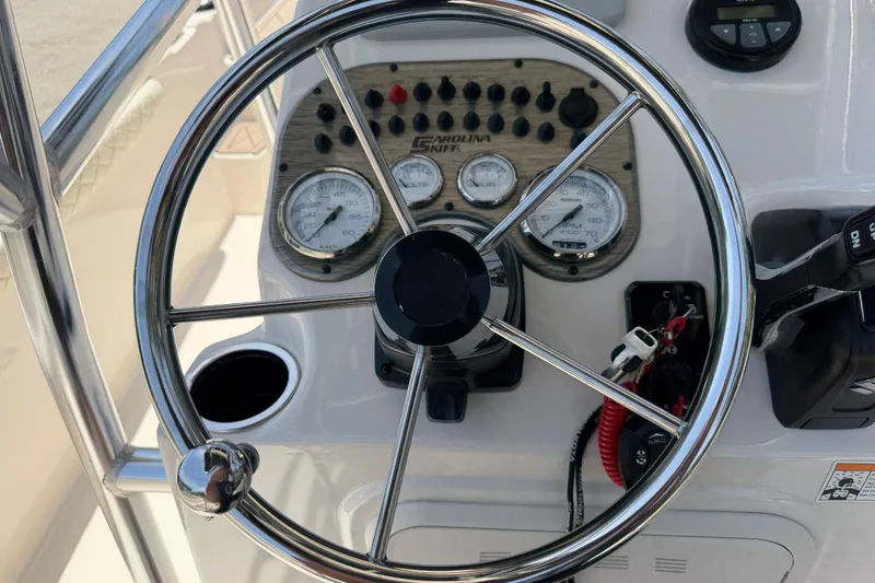 Slide: The Image of 2023 Carolina Skiff 21 LS boat dashboard with steering wheel and gauges. - 56