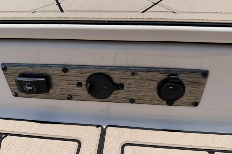 Slide: The Image of Control panel on 2023 Carolina Skiff 21 LS boat, featuring trim switch and 12V outlet. - 70