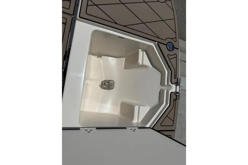 Slide: The Image of 2023 Carolina Skiff 21 LS boat storage compartment, open and empty, with brown deck accents. - 71