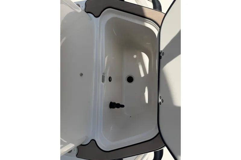 Slide: The Image of 2023 Carolina Skiff 21 LS boat storage compartment, open lid, white interior. - 81