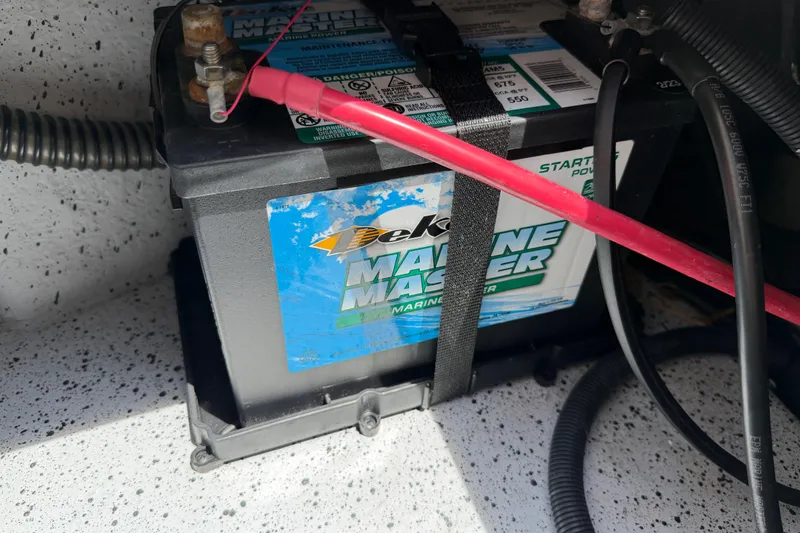 Slide: The Image of Marine battery in a 2023 Carolina Skiff 21 LS boat, secured with cables and straps. - 91