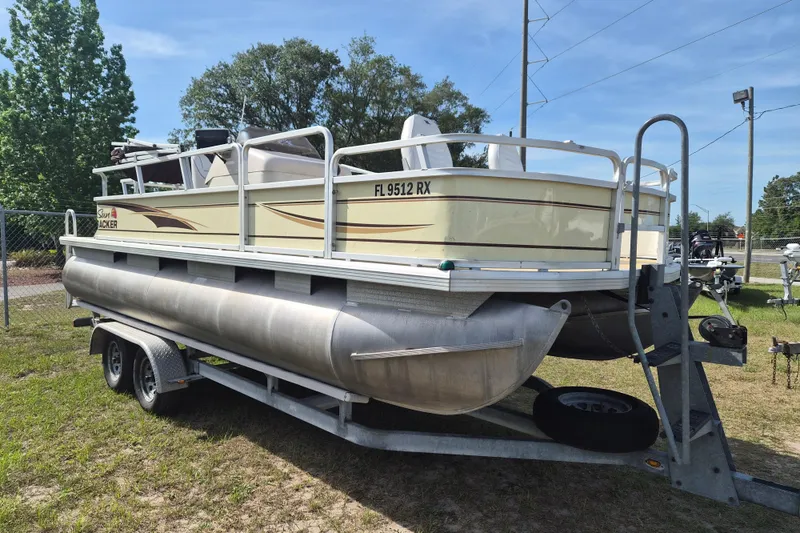 The Image of 2004 Sun Tracker Fishin' Barge 20 DLX pontoon boat on trailer, parked outdoors. - 1