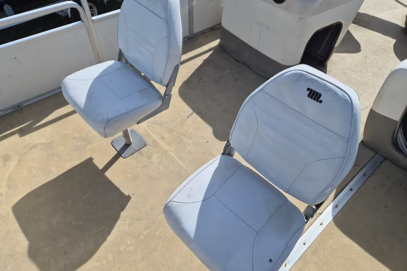 Slide: The Image of 2004 Sun Tracker Fishin' Barge 20 DLX boat seats, white upholstery, outdoor setting. - 12