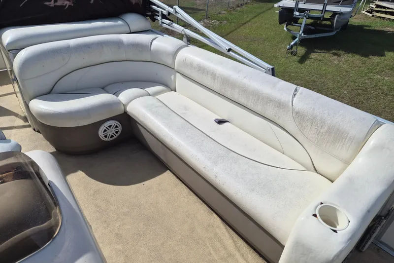 Slide: The Image of 2004 Sun Tracker Fishin' Barge 20 DLX interior seating with white upholstery and cup holder. - 7