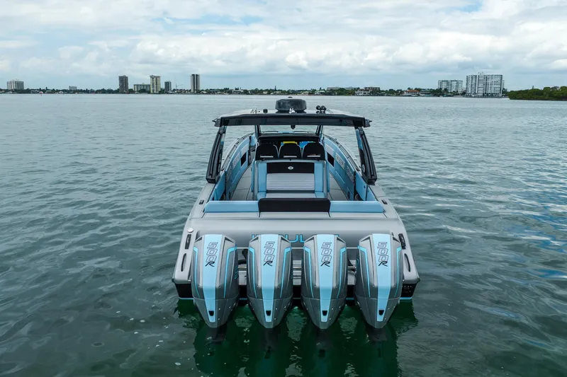 Slide: The Image of 2026 Cigarette 41' Nighthawk boat with four powerful engines on calm water. - 2
