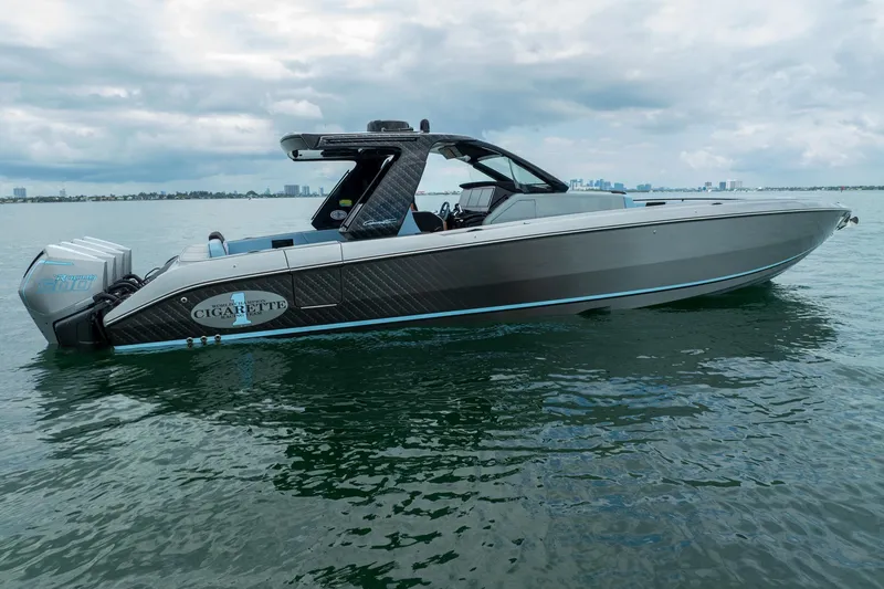 Slide: The Image of 2026 Cigarette 41' Nighthawk boat on water, sleek design, powerful engines, cloudy sky backdrop. - 3