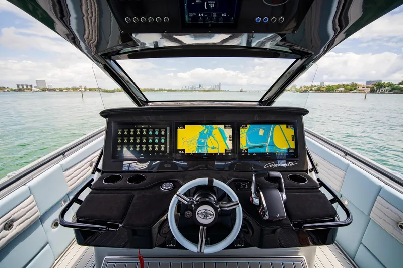 Slide: The Image of Helm of 2026 Cigarette 41' Nighthawk with advanced navigation displays on open water. - 5