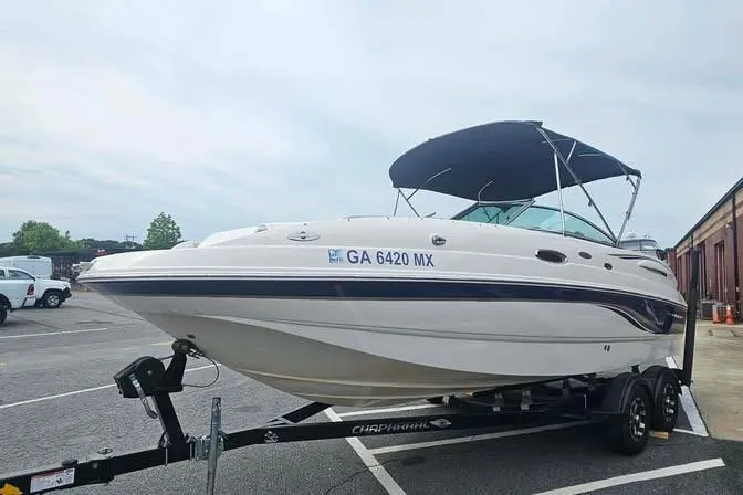 The Image of 2003 Chaparral Sunesta 236 boat on trailer in parking lot, with canopy and registration number. - 1