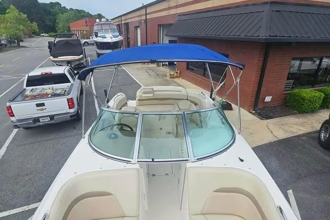 Slide: The Image of 2003 Chaparral Sunesta 236 boat with blue canopy parked near a building. - 11