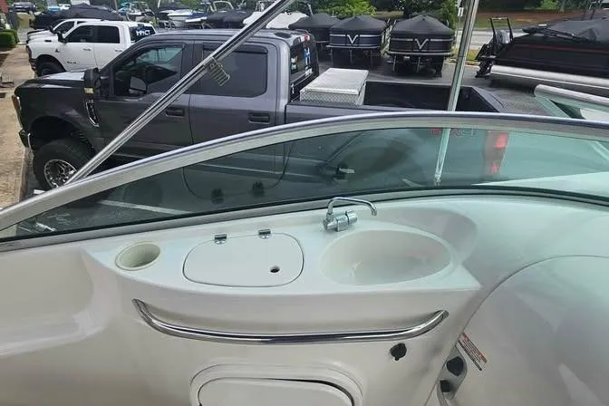 Slide: The Image of 2003 Chaparral Sunesta 236 boat interior with sink and storage, parked near trucks. - 15