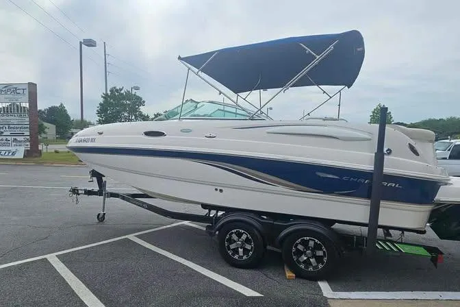 Slide: The Image of 2003 Chaparral Sunesta 236 boat with blue canopy on trailer in parking lot. - 6