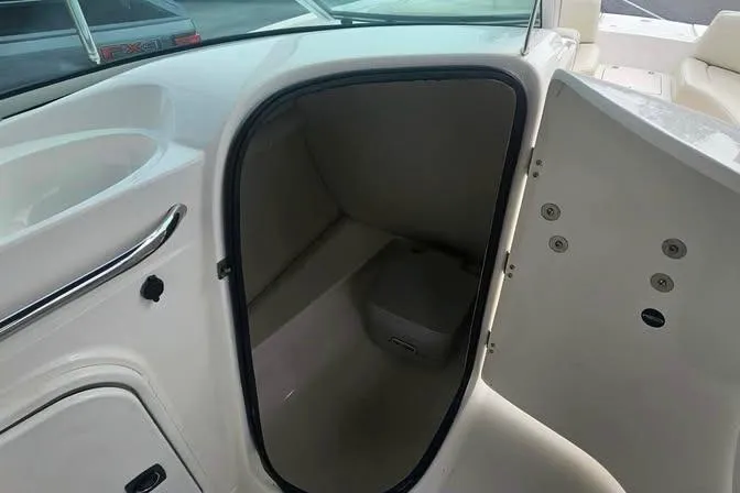 Slide: The Image of 2003 Chaparral Sunesta 236 boat interior storage compartment with open door. - 8