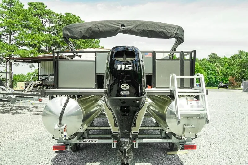 Slide: The Image of 2026 Dockside 22DF pontoon boat with 115 HP engine on a trailer, parked outdoors. - 5