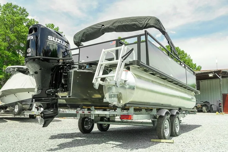 Slide: The Image of 2026 Dockside 22DF pontoon boat with Suzuki engine on trailer, parked outdoors. - 7