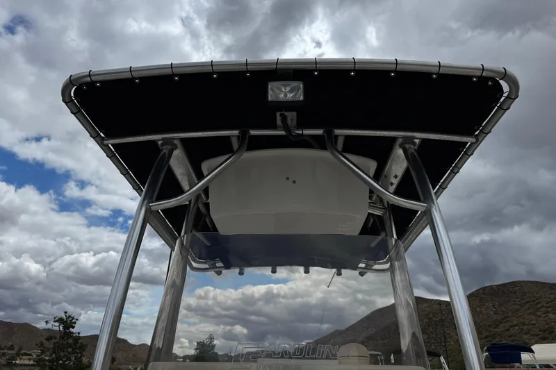 Slide: The Image of 2014 Carolina Skiff 23 Ultra Elite SS boat with T-top under cloudy sky. - 15