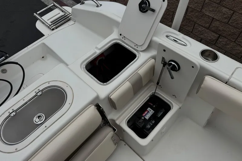 Slide: The Image of 2014 Carolina Skiff 23 Ultra Elite SS boat interior with storage compartments and battery. - 26