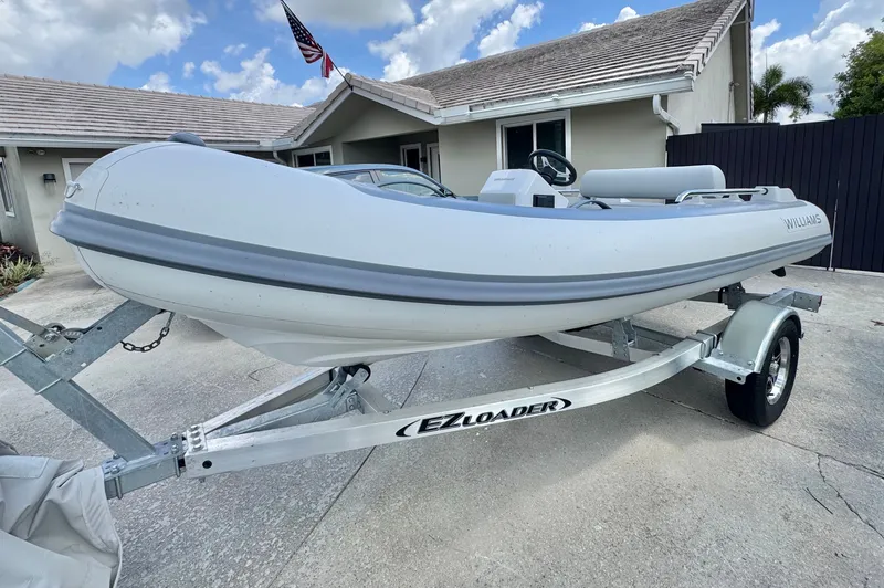 Slide: The Image of 2025 Williams Jet Tenders Sportjet 395 on trailer in front of house. - 2