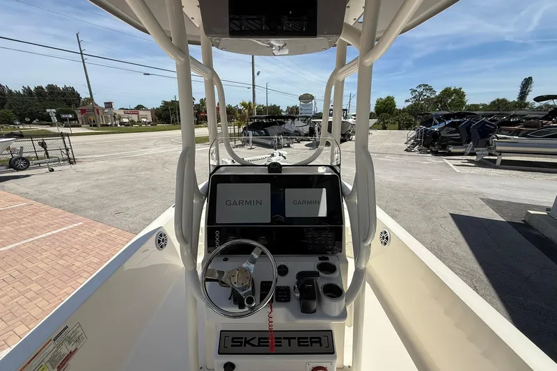 Slide: The Image of 2023 Skeeter SX2350 boat console with Garmin displays and steering wheel in a dealership lot. - 12